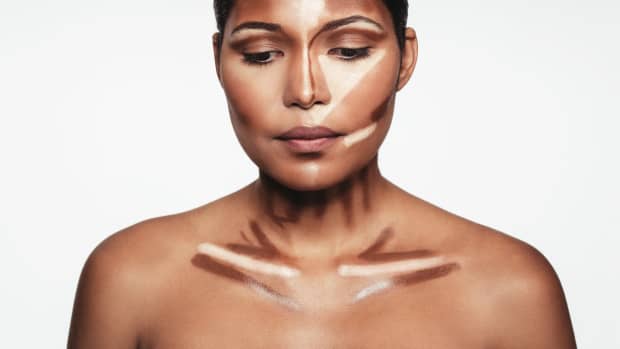 woman highlighting and contouring her face and neck.