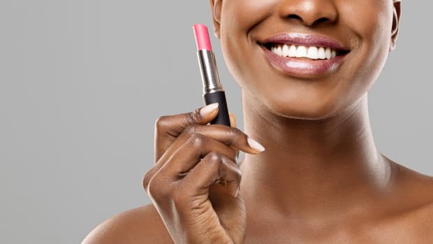woman holds lipstick in her hand.