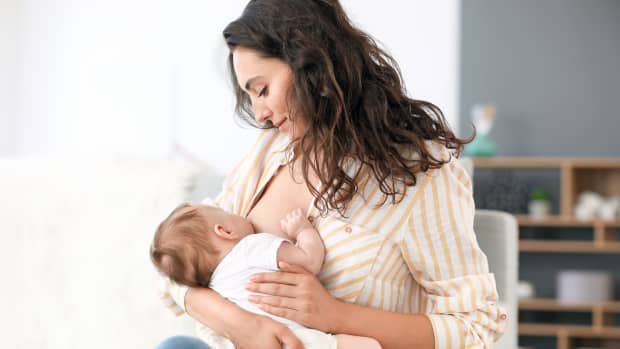 woman breastfeeding her child in casual wear