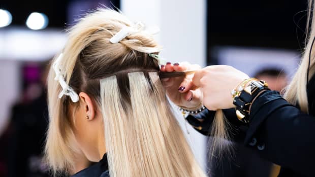 a woman getting blonde tape-in hair extensions