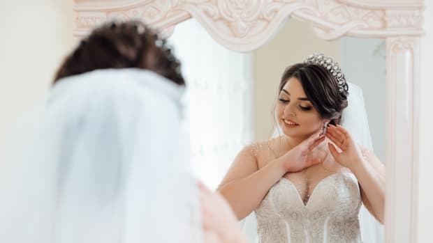 a plus-size bride looking in the mirror
