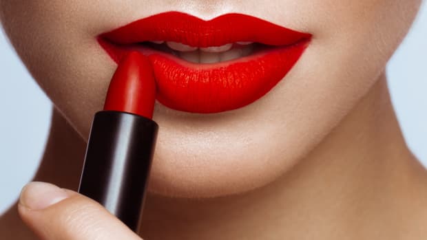 close up of a woman applying red lipstick