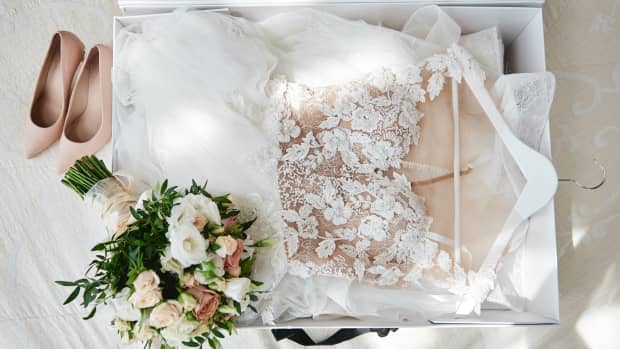 wedding dress in a box with a bouquet and heels