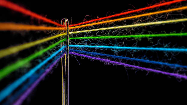 close up of needle and rainbow thread