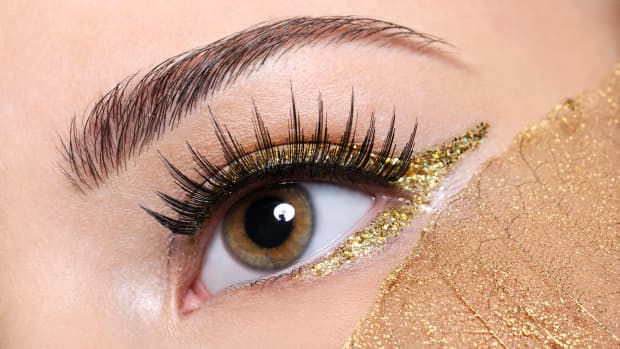 a woman's eye with gold eyeliner