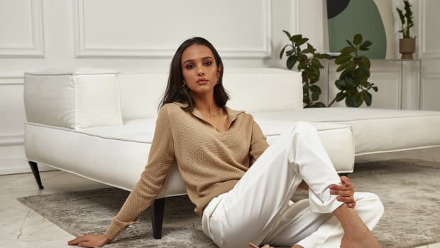 Brown woman sitting with white pants on