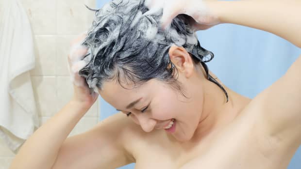 Asian woman shampooing her hair