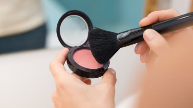 a woman getting ready to apply blush