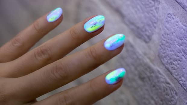 hand with glow in the dark manicure.