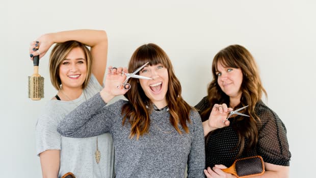 three women pose with brushes and scissors.