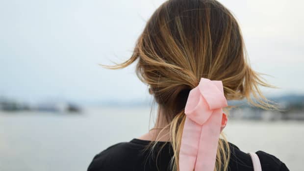blond haired woman with a pink bow in their hair.