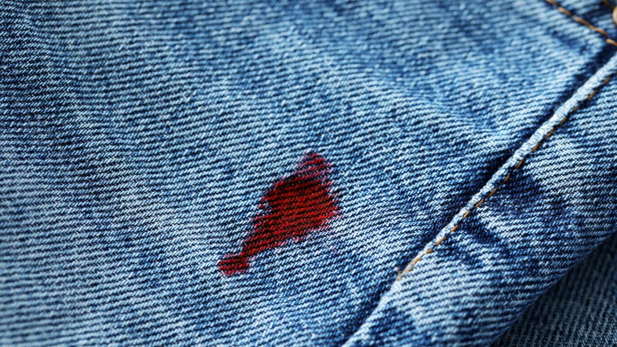 Blood Stain On Jeans Background. Jeans Texture Stock Photo