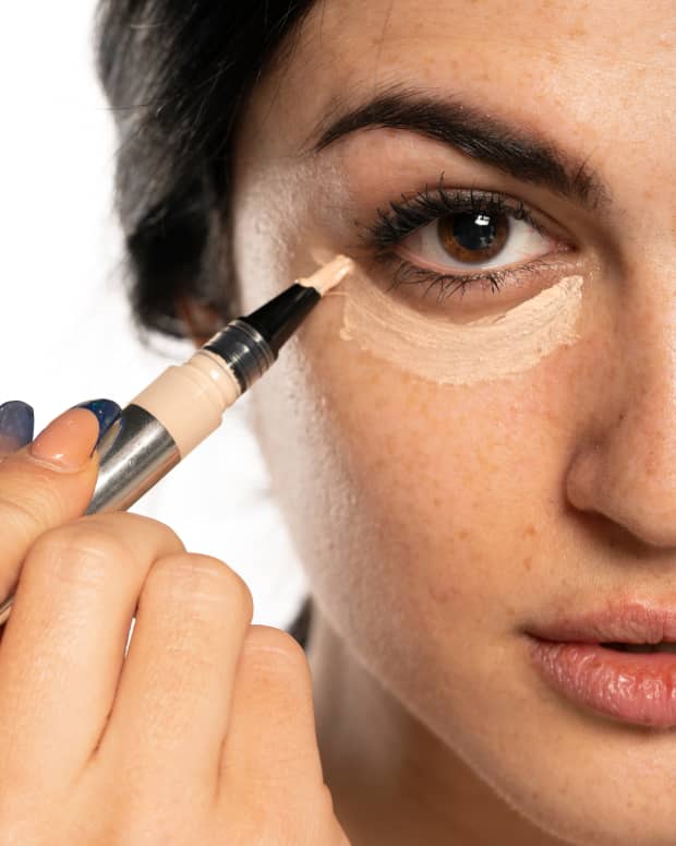 a woman applying concealer